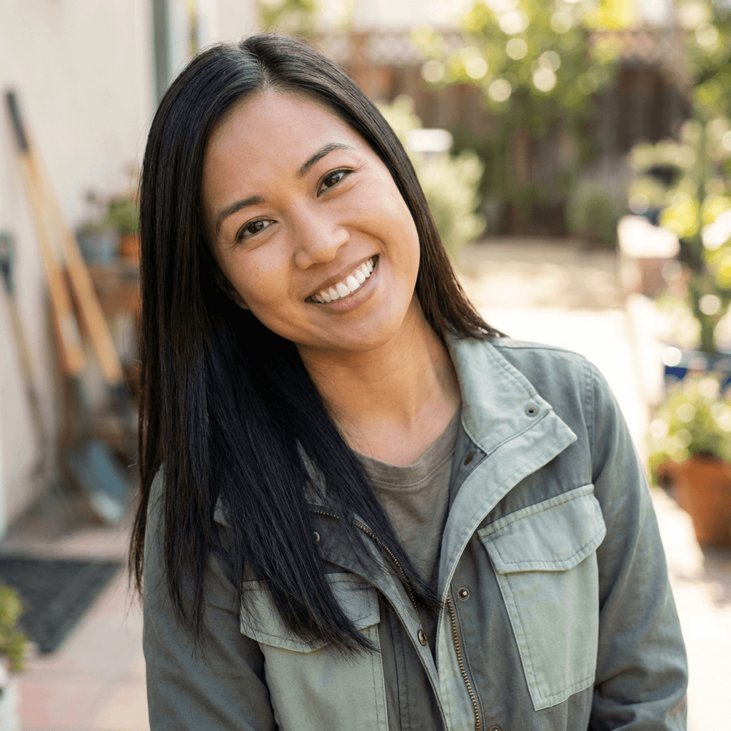 Female cafe owner in her late 30s, smiling, behind a coffee counter